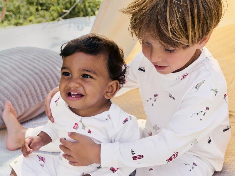 a young boy and girl playing with each other on a bed