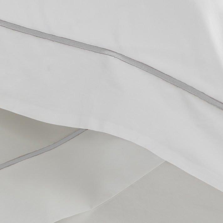 a close up of a white sheet with a silver stripe
