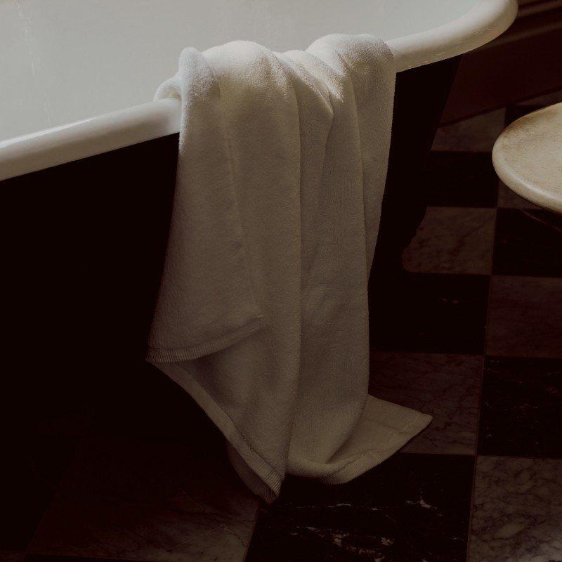 a bathtub with a towel hanging from the side of it