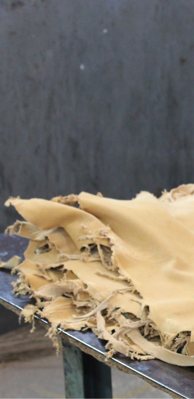 a man cutting up a piece of cloth on a table