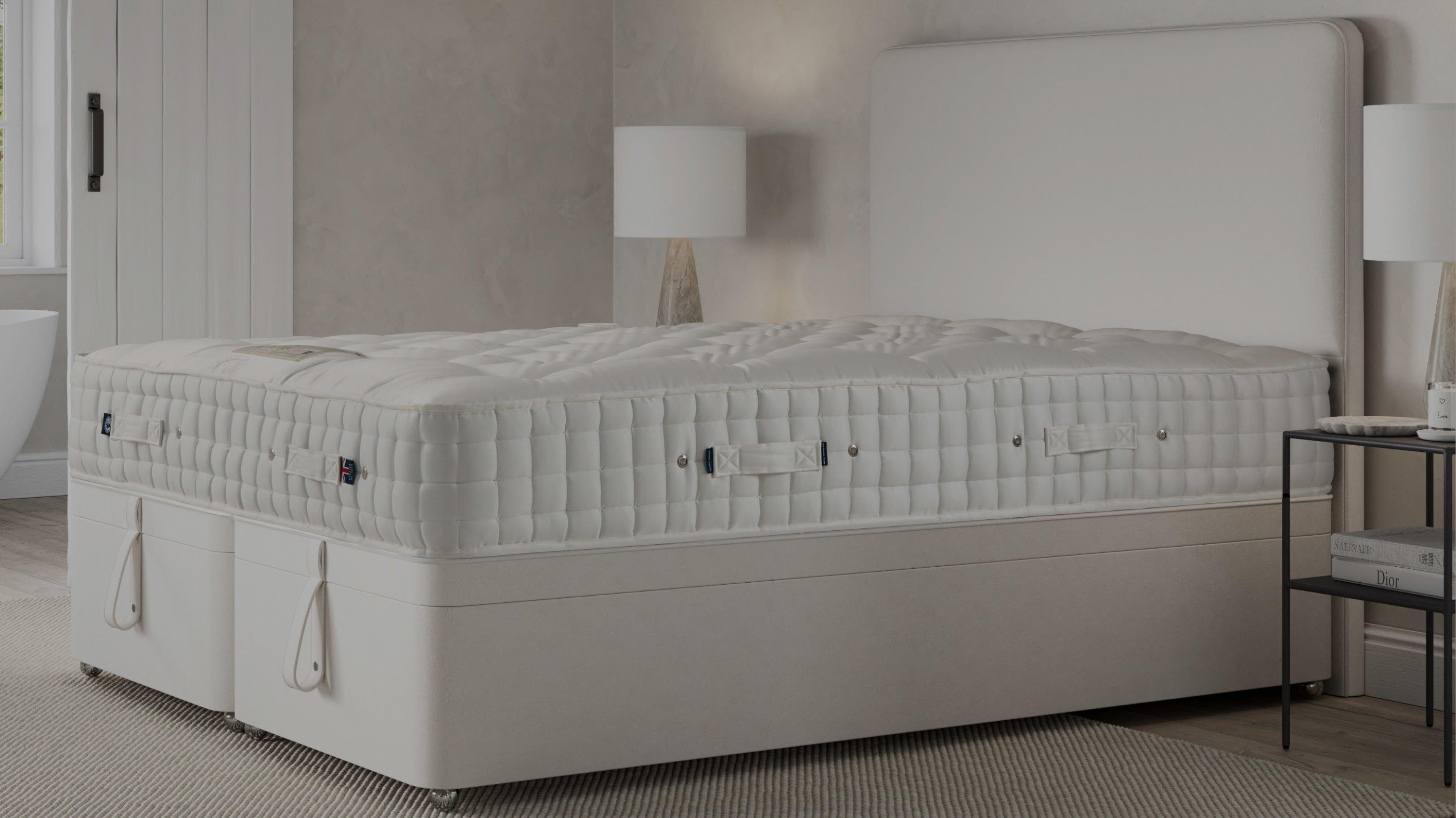 a white bed with a white mattress in a bedroom