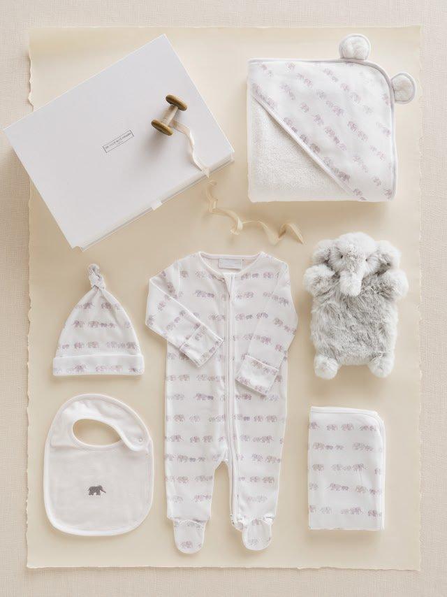 six pairs of baby socks are arranged on a white surface
