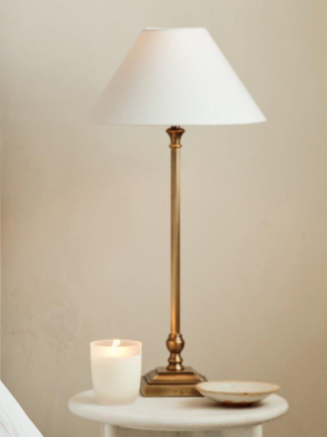 a small table with a lamp and a small plate of food