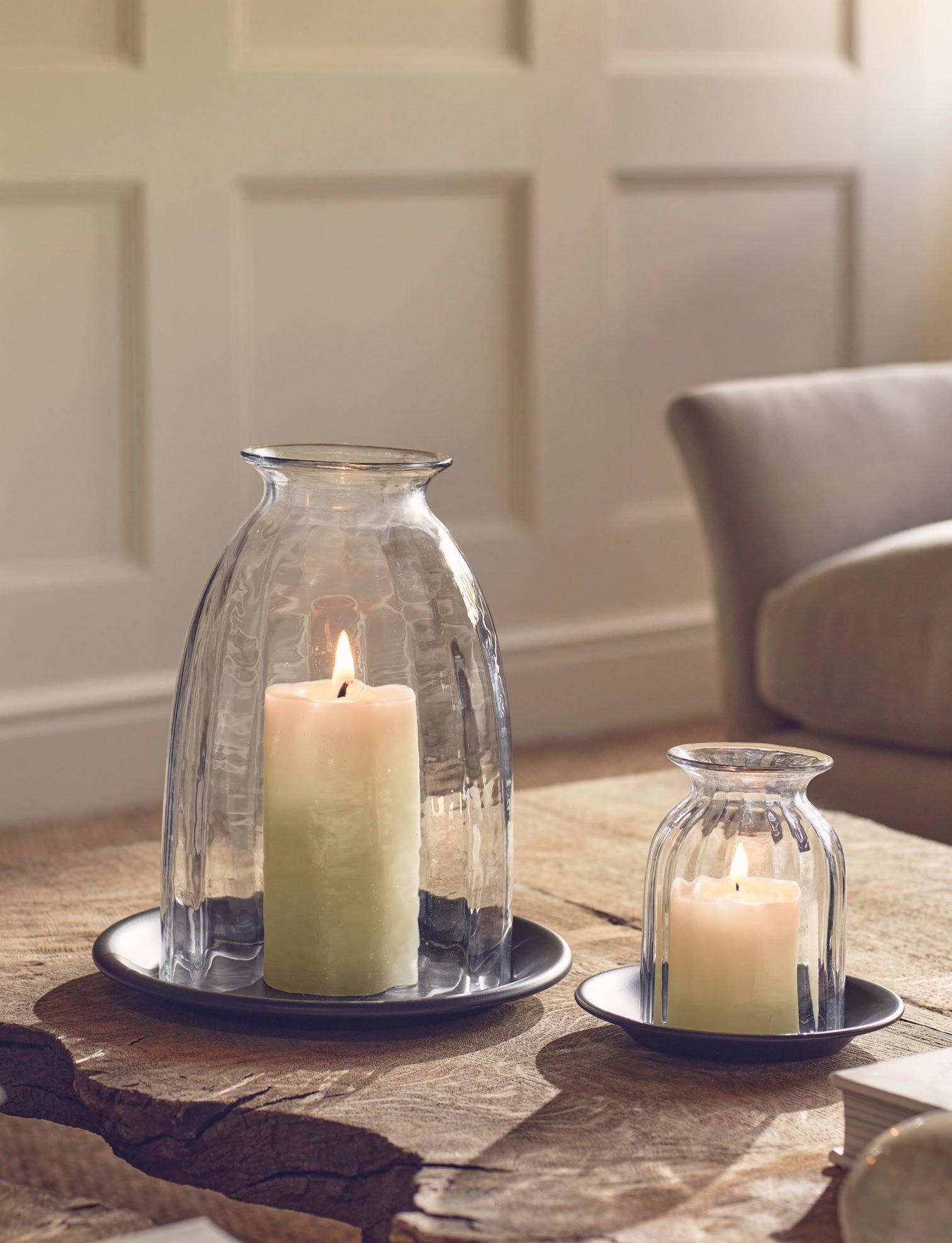 a couple of two candles sitting on a table next to each other