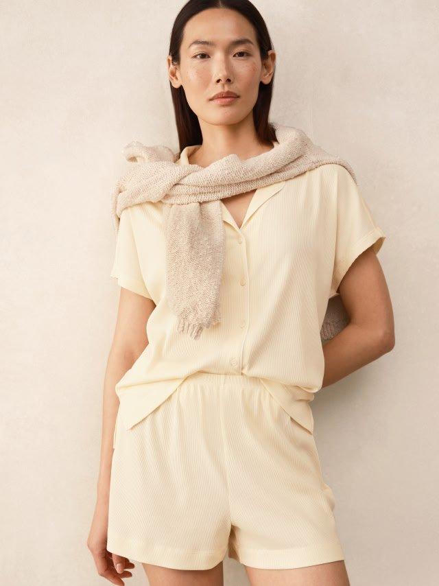 a woman in a white shirt and shorts posing for a picture