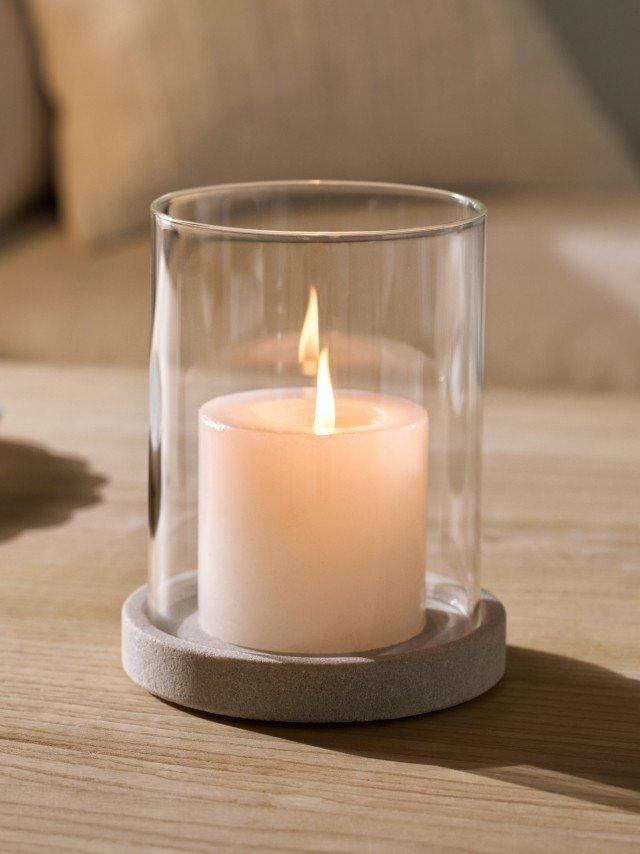 a candle sitting in a glass container on a table