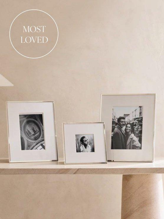 three framed pictures sit on a table with a white marble top