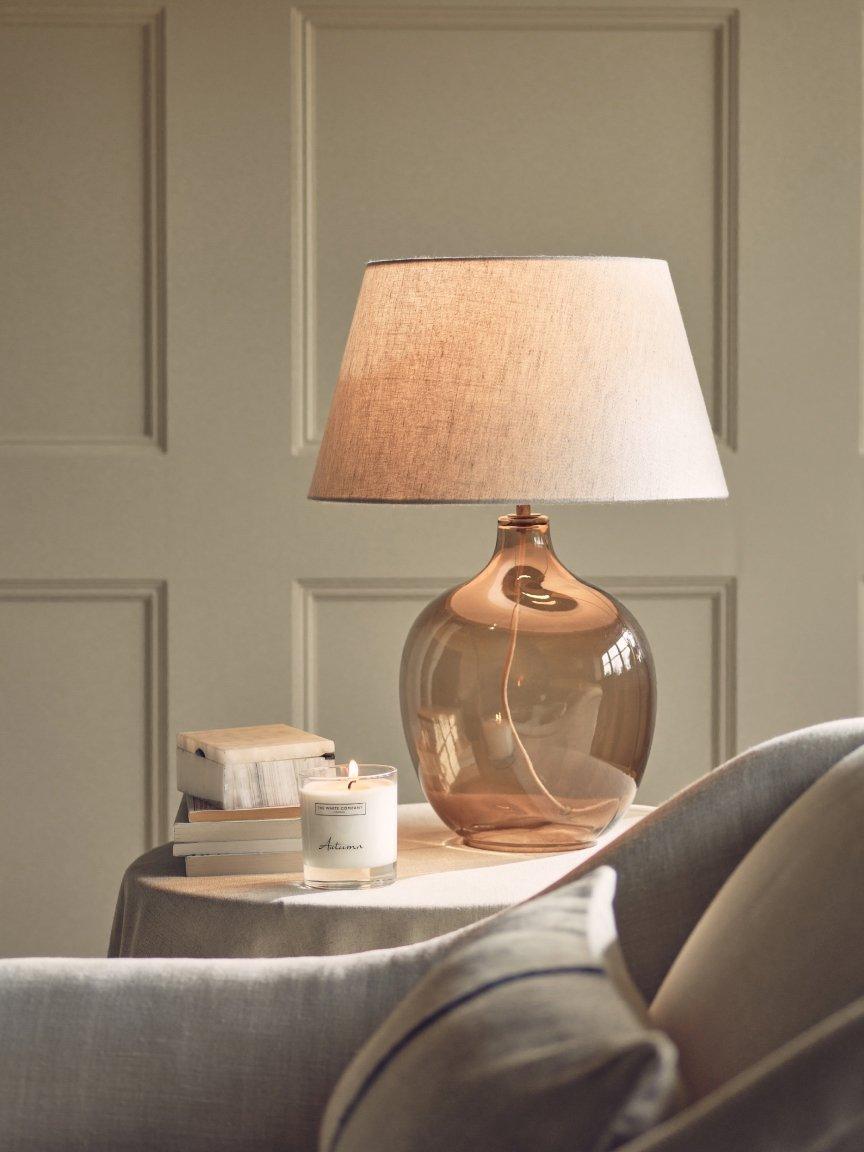 a table with a lamp on it and a book on it