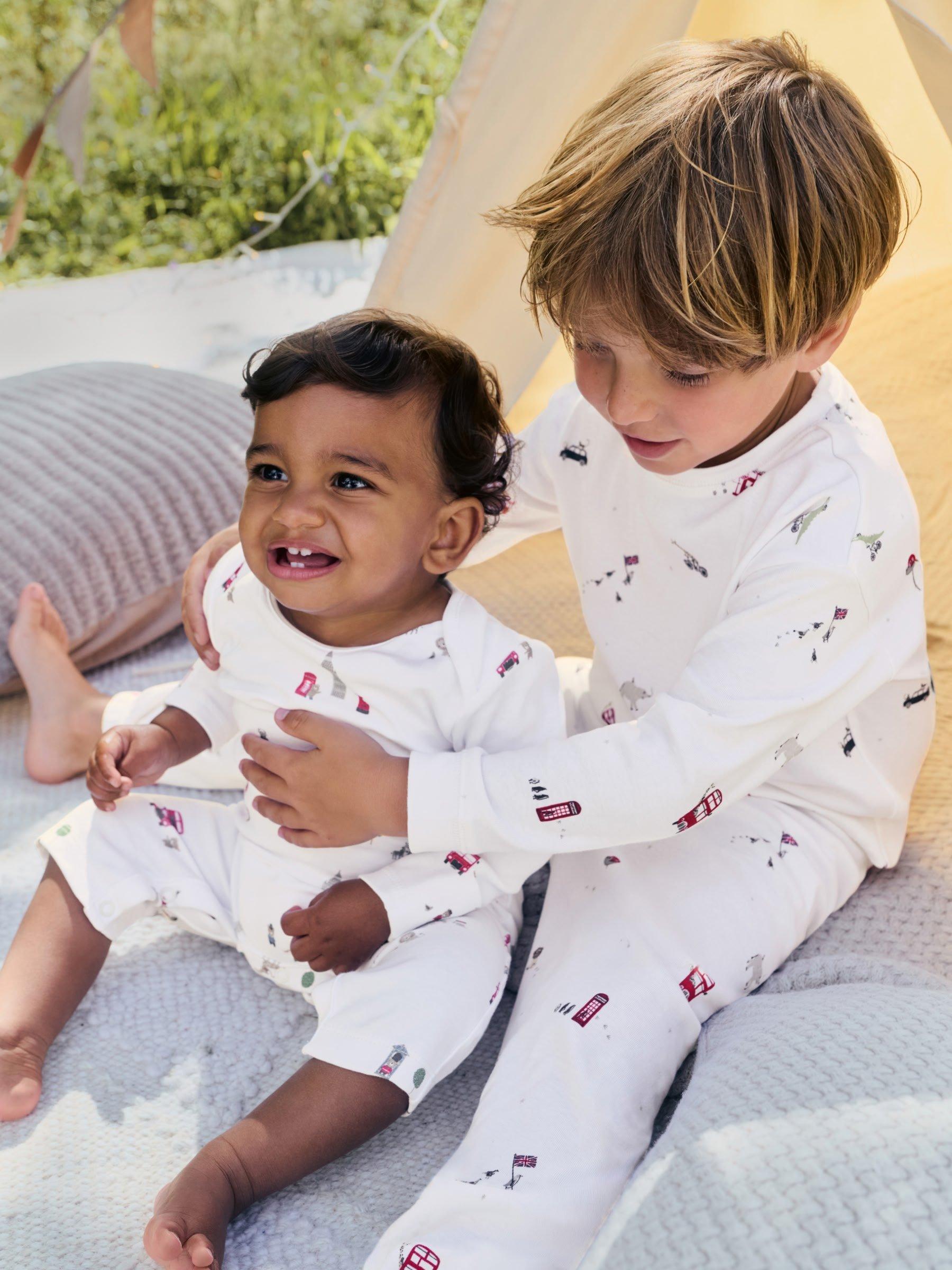 2 boys in matching pyjamas in a tent