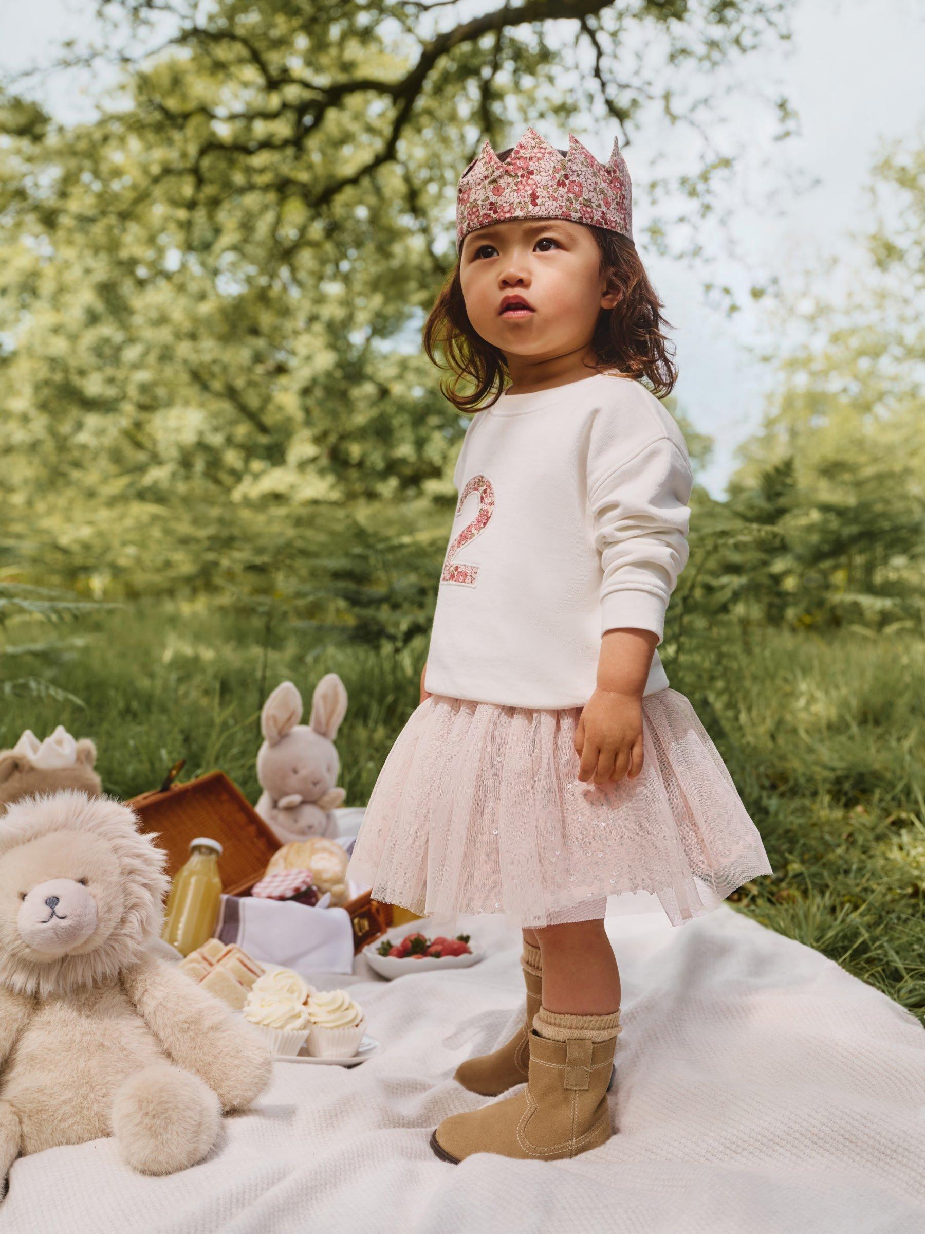 girl in a pink outfit at a picnic