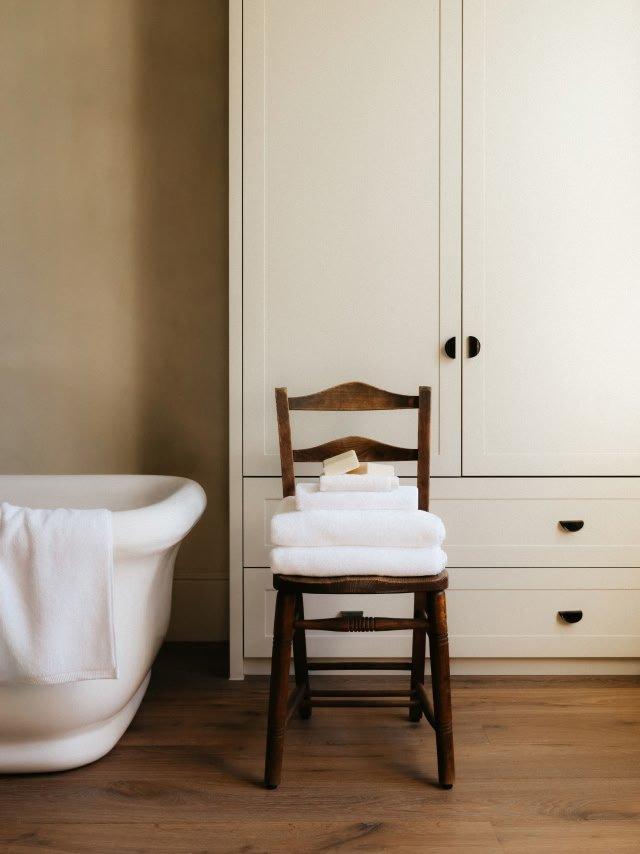a chair sitting next to a bathtub in a bathroom