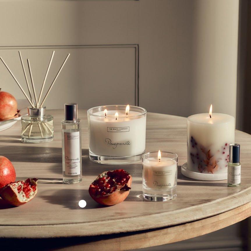 a table with candles, pomegranates and other items on it