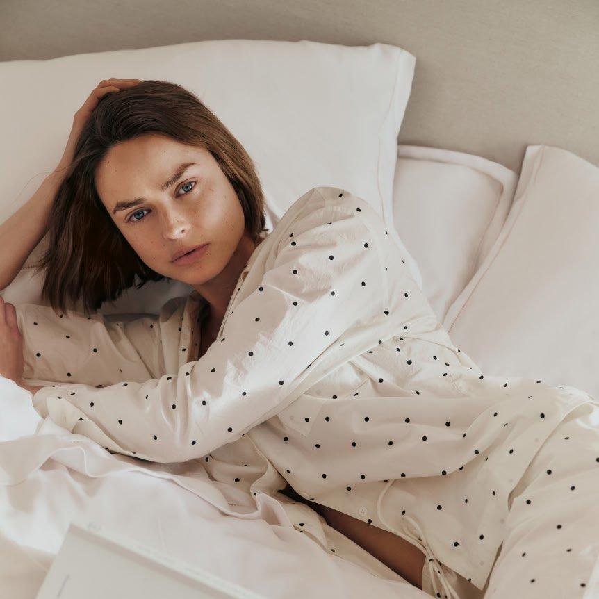 a woman laying in bed with laptop on her lap