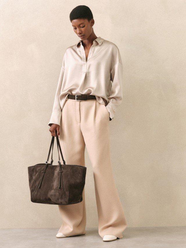 a woman in beige pants and a brown purse