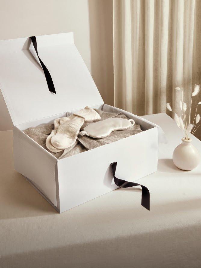 a white box with a vase and some socks in it