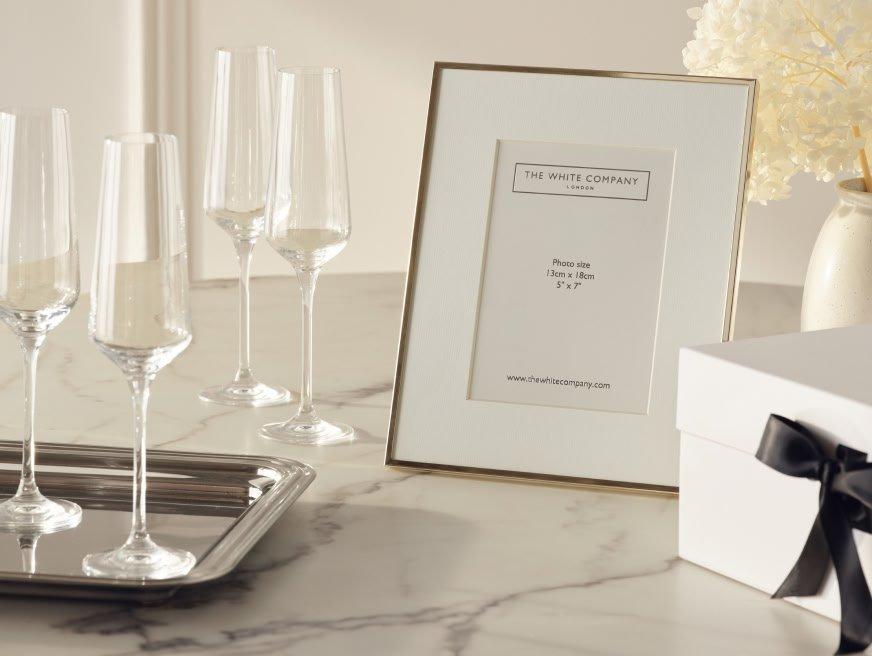 a table with a tray with wine glasses and a picture frame