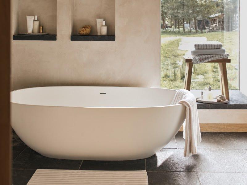 a bathroom with a tub and a window with curtains