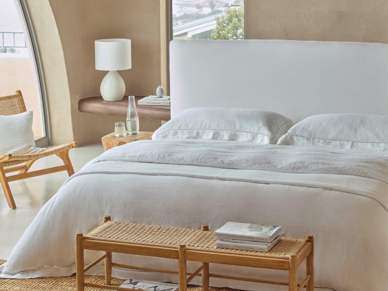 a bedroom with a white bed and a chair in it