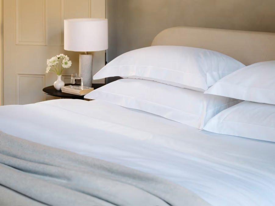 a bed with a white comforter and pillows on it
