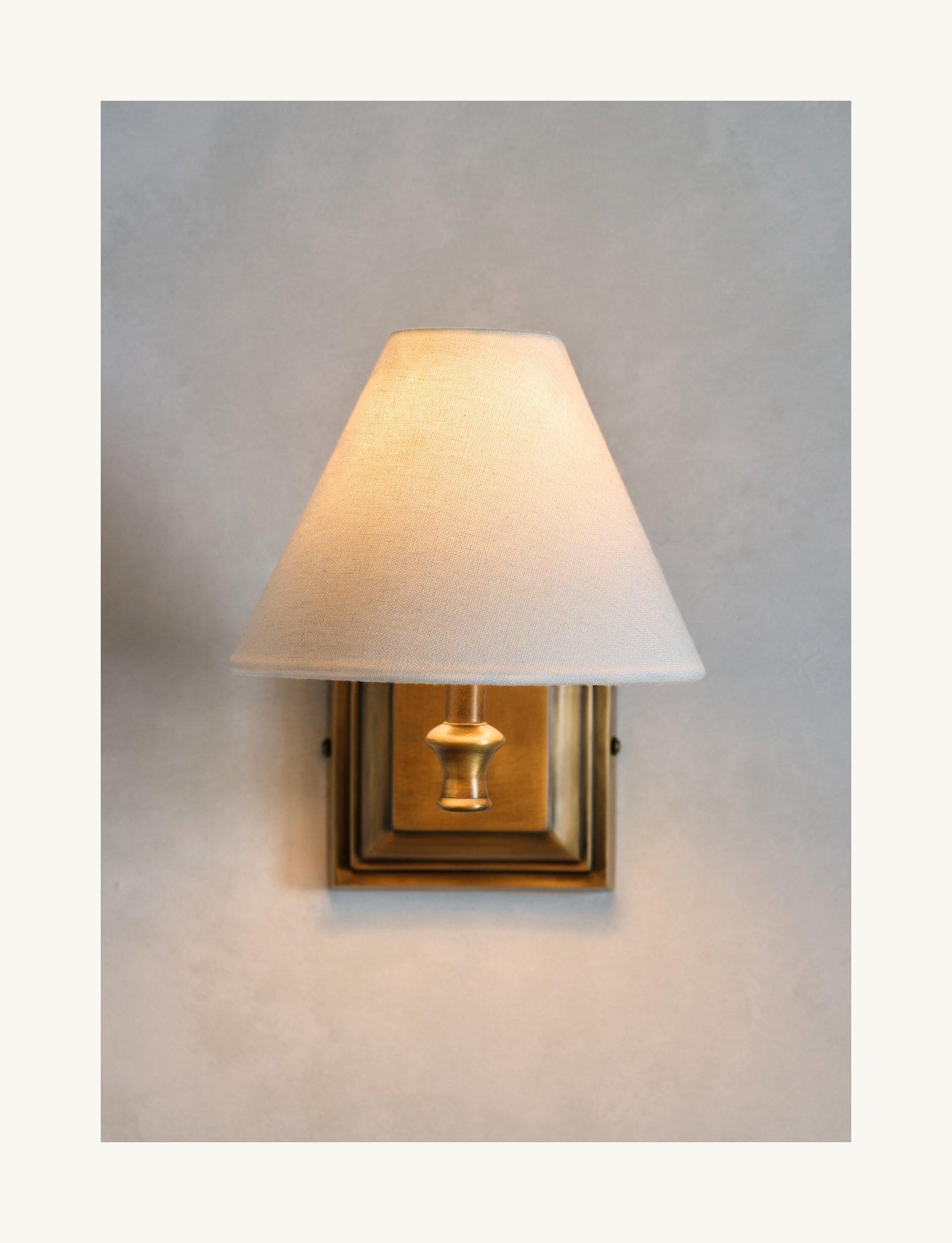bronze and white wall light on a white wall